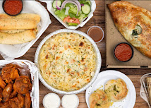 Family-style spread of pizza, calzone, wings, and garlic rolls at Verona's